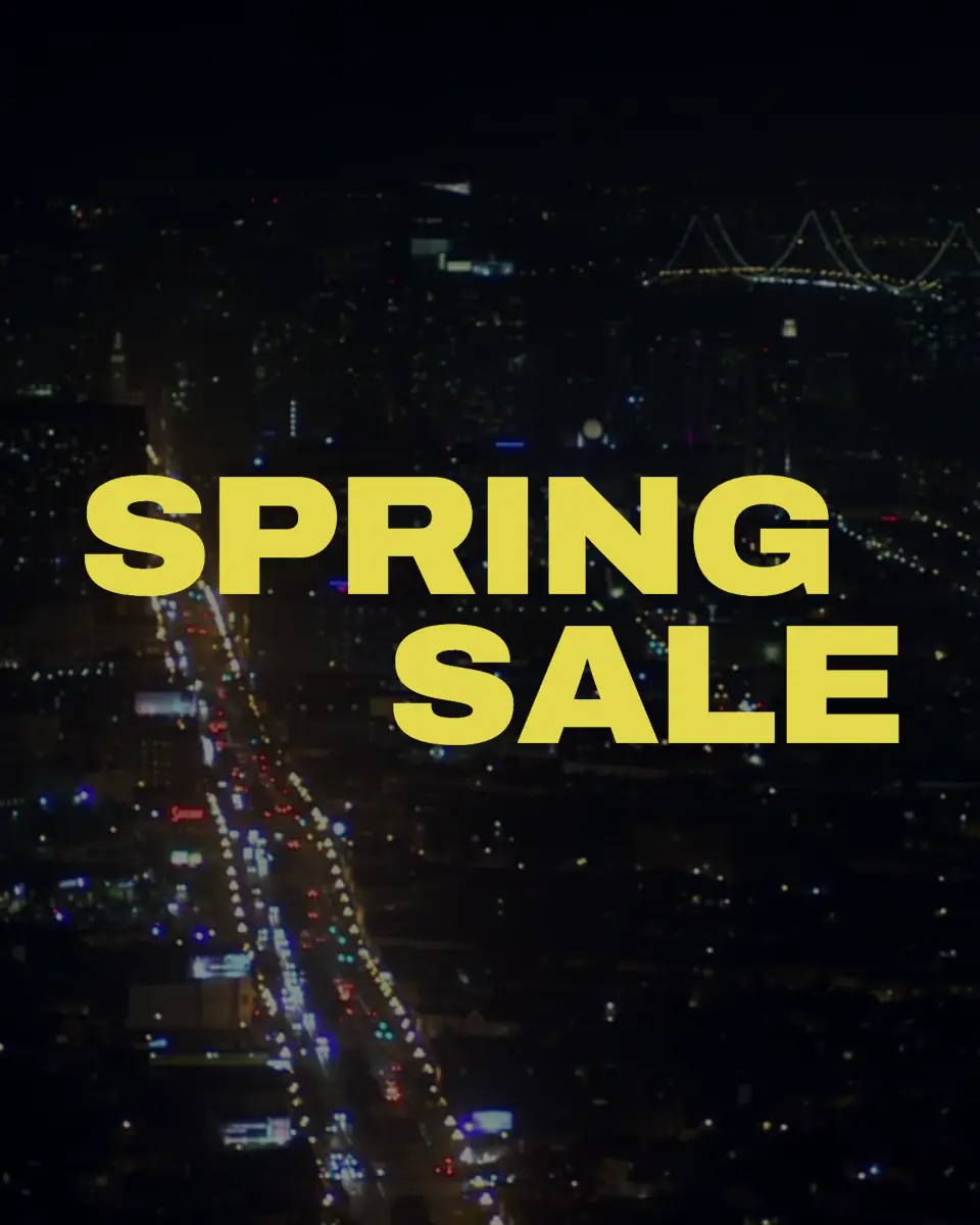 A comp frame: the words SPRING SALE in heavy yellow type over night footage of a city street.